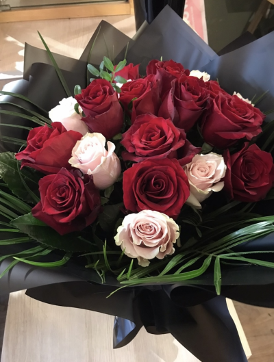 Lux 20 Rose Hand Tied bouquet - A hand tied bouquet of long stem, large red and blush roses. Presented in dramatic black wraps and a black box.